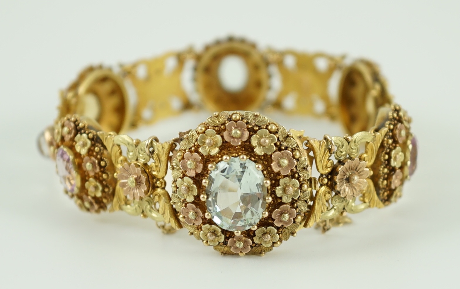 A 19th century pierced three colour gold, pink topaz, moonstone, citrine and aquamarine set bracelet.